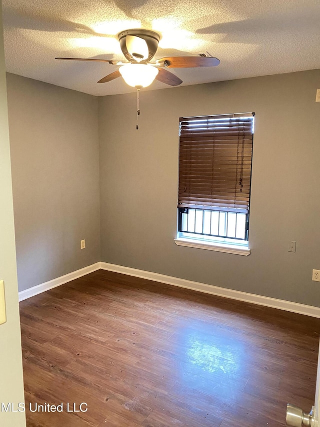 spare room featuring ceiling fan, dark hardwood / wood-style floors, and a textured ceiling