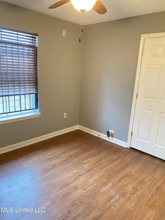 empty room with ceiling fan and wood-type flooring