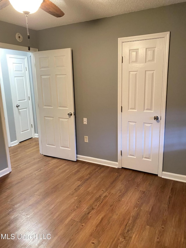 unfurnished bedroom featuring hardwood / wood-style flooring and a textured ceiling