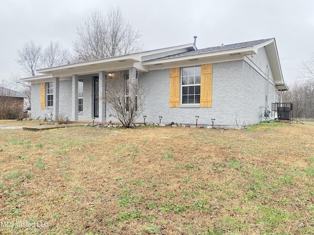 single story home featuring central AC unit and a front lawn