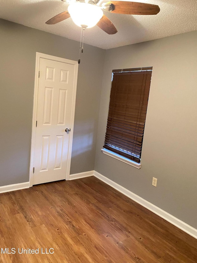 spare room featuring ceiling fan, wood-type flooring, and a textured ceiling