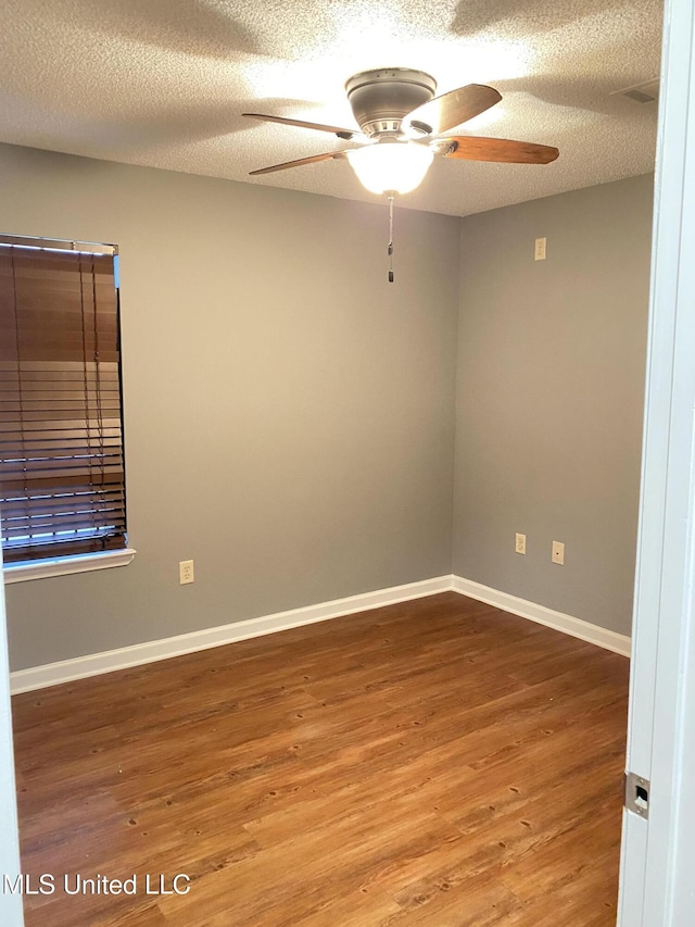 unfurnished room with hardwood / wood-style flooring, ceiling fan, and a textured ceiling