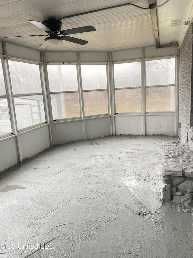 unfurnished sunroom with ceiling fan