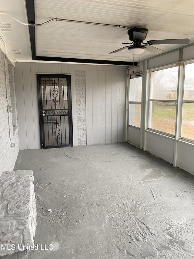 unfurnished sunroom with ceiling fan