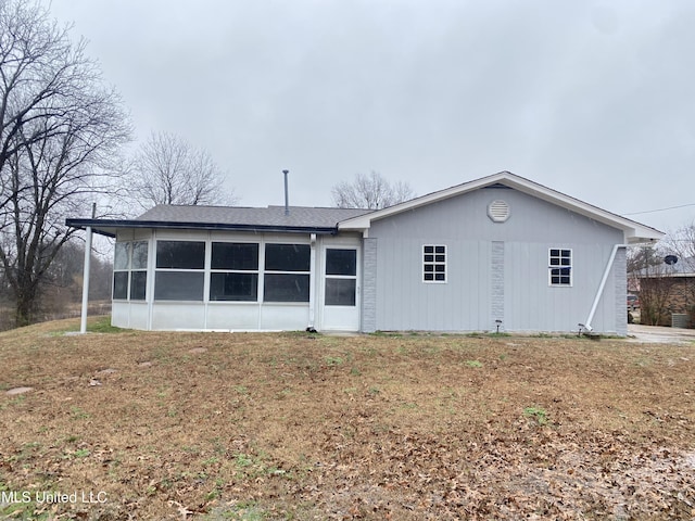 back of house with a yard and a sunroom