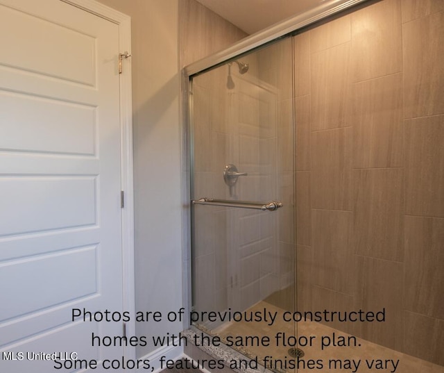 bathroom featuring a shower with shower door