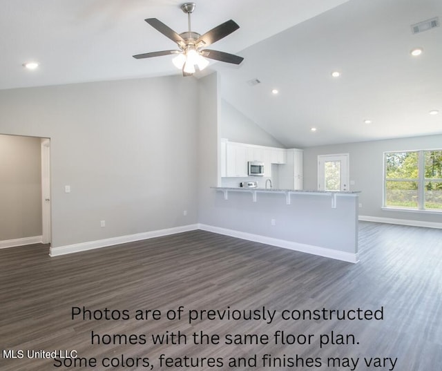 unfurnished living room with dark wood-type flooring, ceiling fan, and high vaulted ceiling