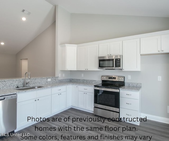 kitchen with dark hardwood / wood-style floors, sink, light stone countertops, white cabinets, and appliances with stainless steel finishes