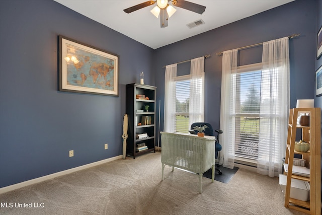 carpeted office space featuring ceiling fan