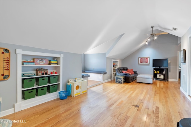 playroom with hardwood / wood-style flooring, ceiling fan, built in features, and vaulted ceiling