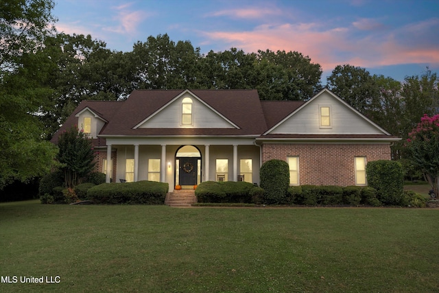 view of front facade featuring covered porch and a lawn