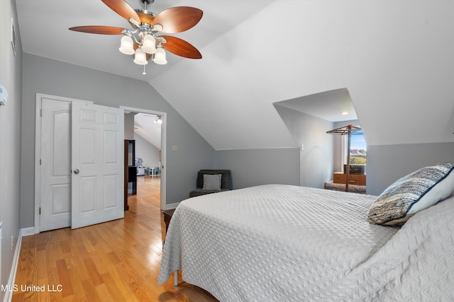 bedroom featuring light hardwood / wood-style floors, ceiling fan, and vaulted ceiling