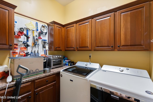 laundry area featuring washing machine and clothes dryer and cabinets