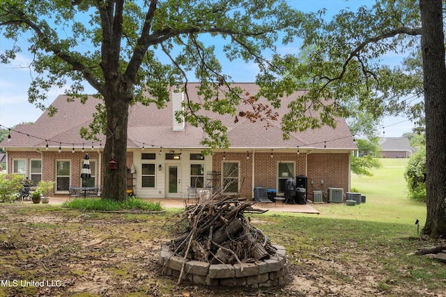 back of property with a yard, a patio area, and cooling unit