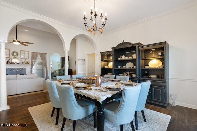 dining space with crown molding, ornate columns, ceiling fan with notable chandelier, and dark hardwood / wood-style flooring