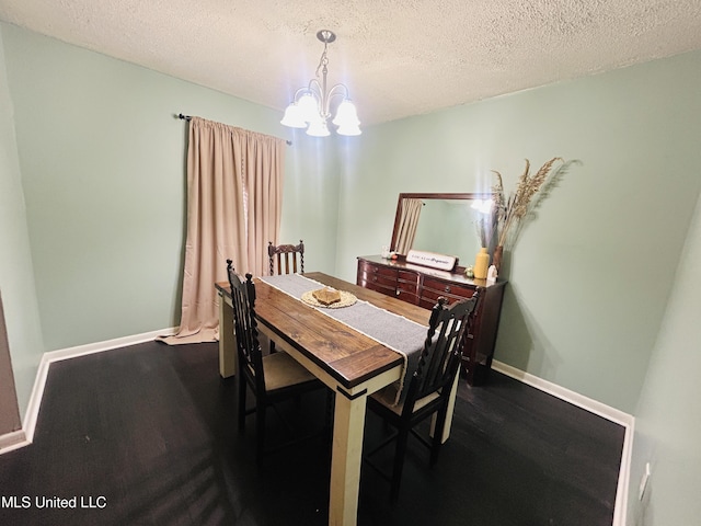 dining area featuring dark hardwood / wood-style floors, a textured ceiling, and an inviting chandelier