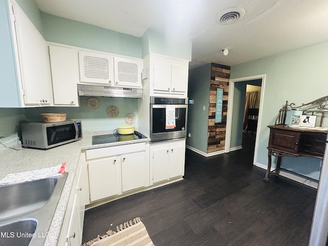 kitchen with white cabinets, appliances with stainless steel finishes, dark hardwood / wood-style floors, and sink