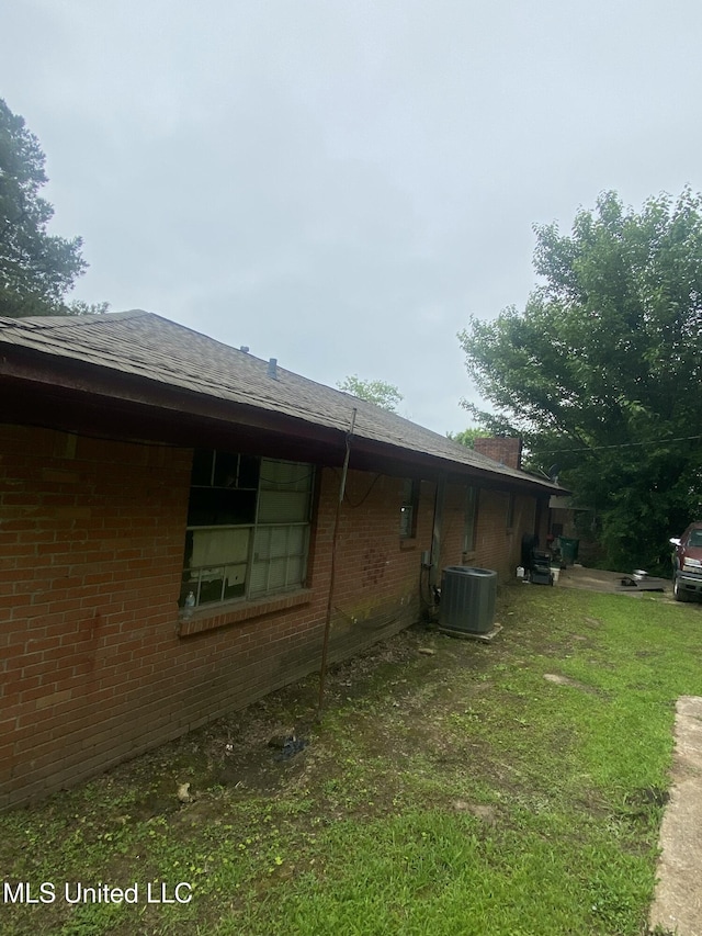 351 E Academy St, Canton, MS 39046 - view of side of property with brick siding, central AC unit, and a yard