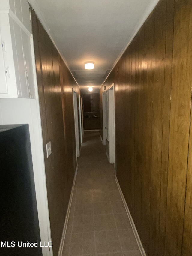 351 E Academy St, Canton, MS 39046 - hall with wooden walls and dark tile patterned floors