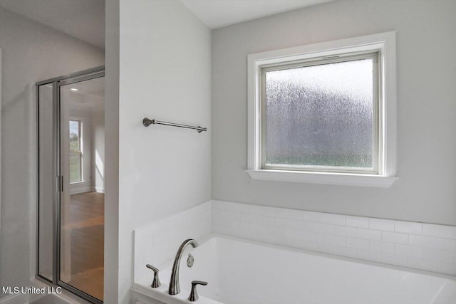 bathroom featuring plus walk in shower and a wealth of natural light