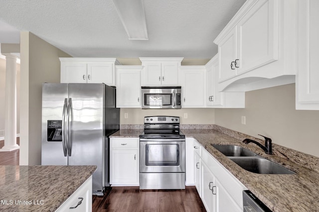 2338 Khushboo Cv, Southaven, MS 38671 - kitchen with appliances with stainless steel finishes, ornate columns, white cabinets, and a textured ceiling