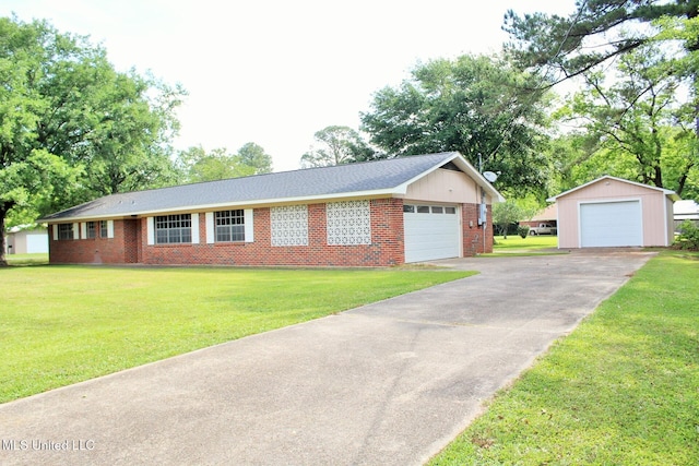 ranch-style house with a detached garage, brick siding, an outbuilding, and a front lawn
