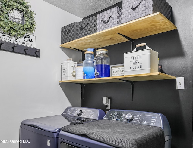 clothes washing area featuring a textured ceiling, washing machine and clothes dryer, and laundry area