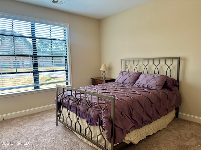 carpeted bedroom featuring multiple windows