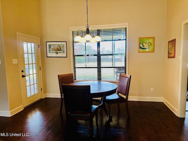 dining area featuring dark hardwood / wood-style floors and an inviting chandelier