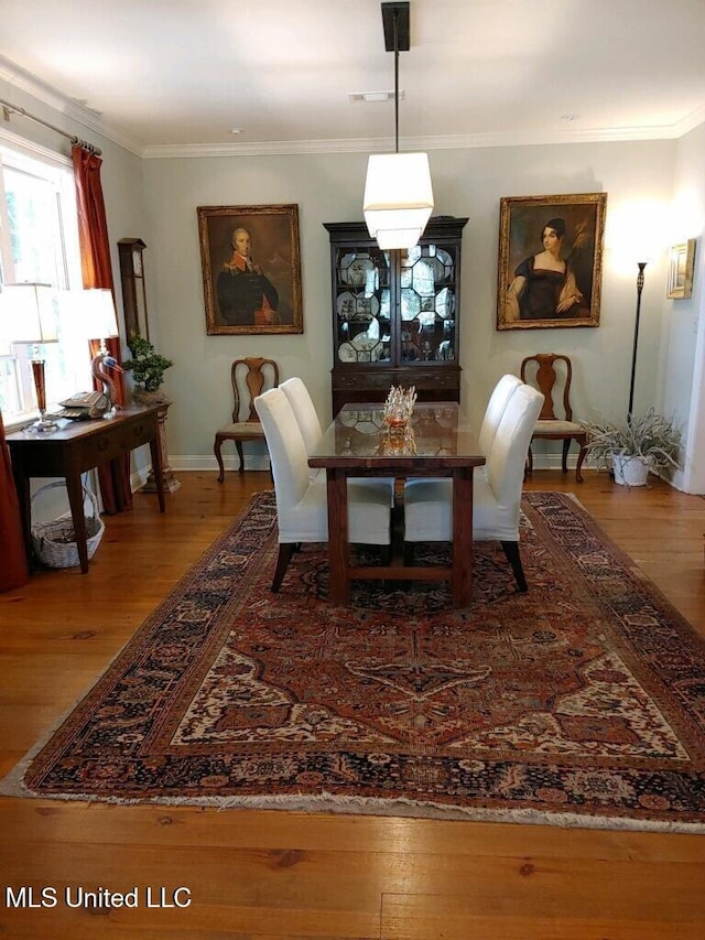 dining area with visible vents, crown molding, and hardwood / wood-style floors