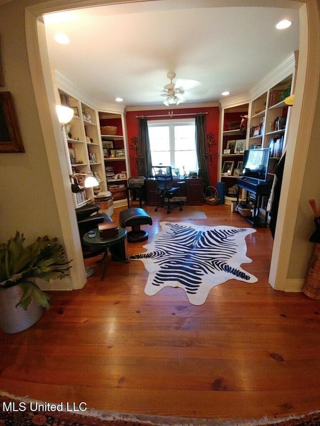 interior space with ornamental molding, ceiling fan, and wood finished floors