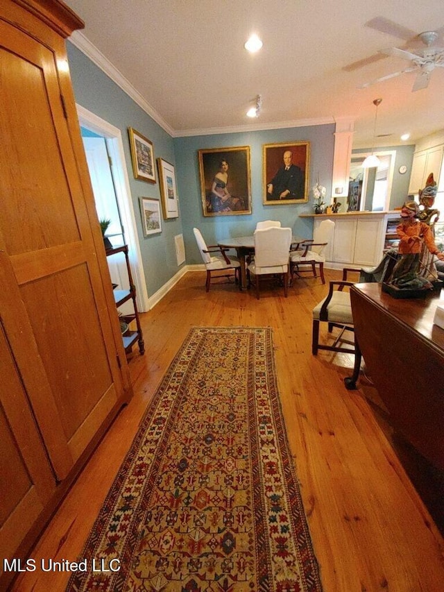 corridor with crown molding, baseboards, and wood finished floors