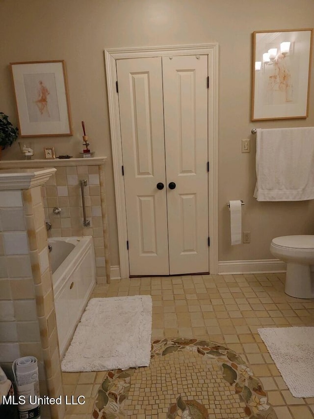 full bath featuring a bath, tile patterned floors, toilet, and baseboards