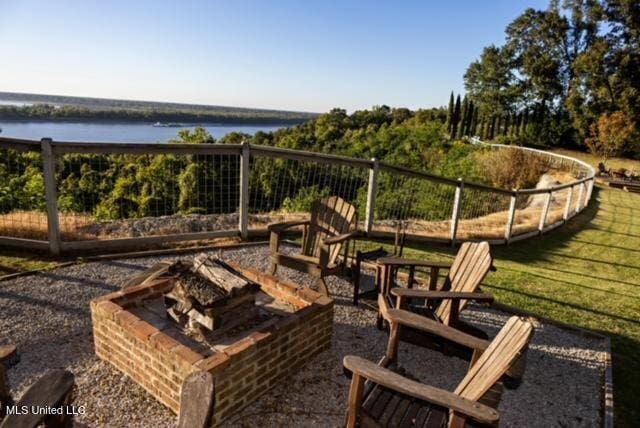 exterior space with a water view and an outdoor fire pit