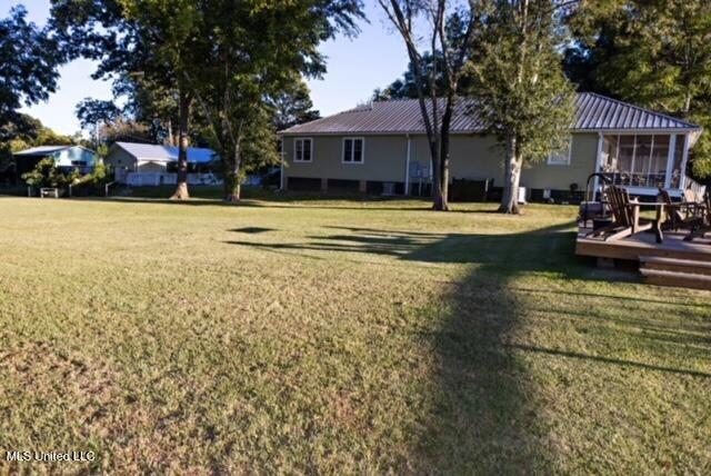 view of yard with a sunroom and a wooden deck