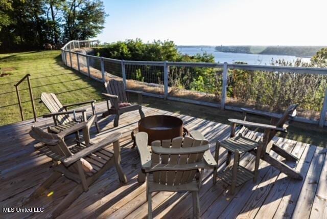 wooden terrace with a yard, a water view, and an outdoor fire pit