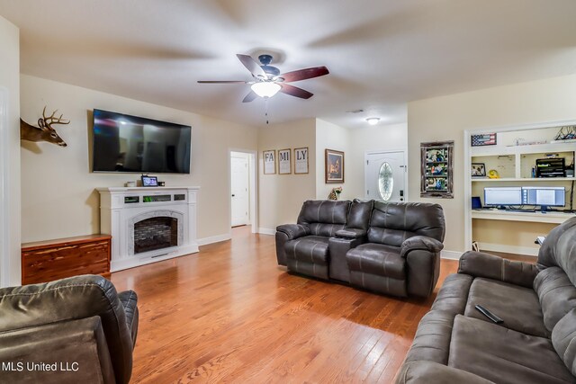 living room with light hardwood / wood-style flooring and ceiling fan