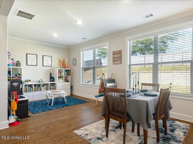 dining space featuring hardwood / wood-style floors and ornamental molding