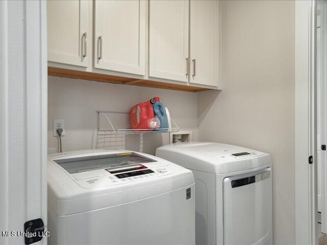 laundry room featuring cabinets and washing machine and clothes dryer