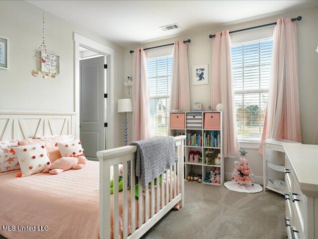 bedroom with light carpet and multiple windows