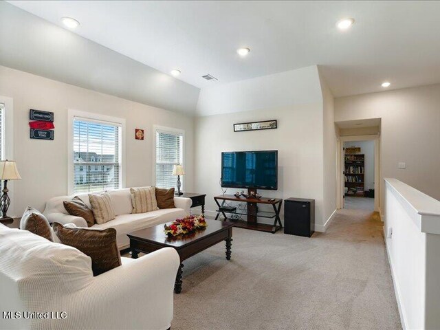 carpeted living room with lofted ceiling