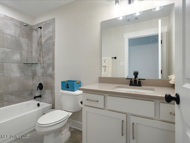 full bathroom featuring vanity, toilet, and tiled shower / bath