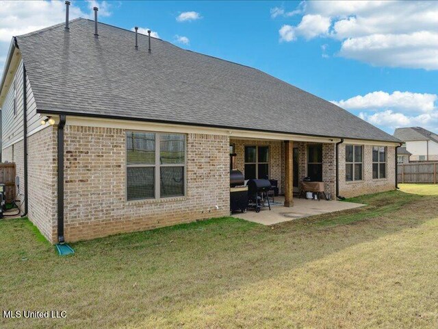 back of house featuring a lawn and a patio area