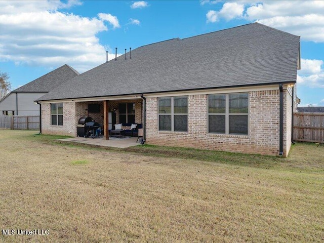 rear view of house featuring a lawn and a patio