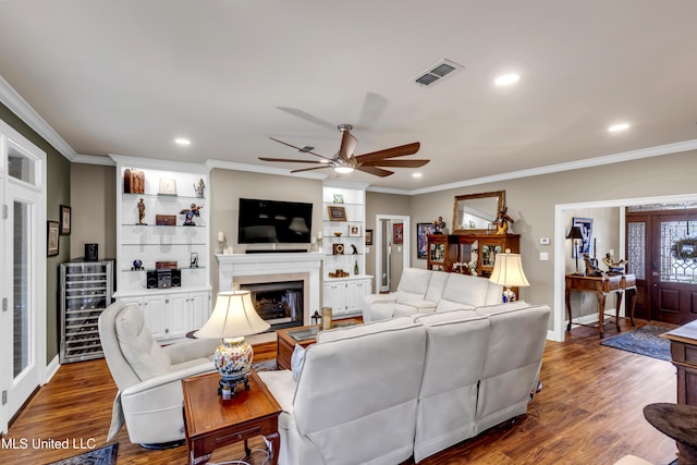 living room with wine cooler, wood finished floors, and ornamental molding
