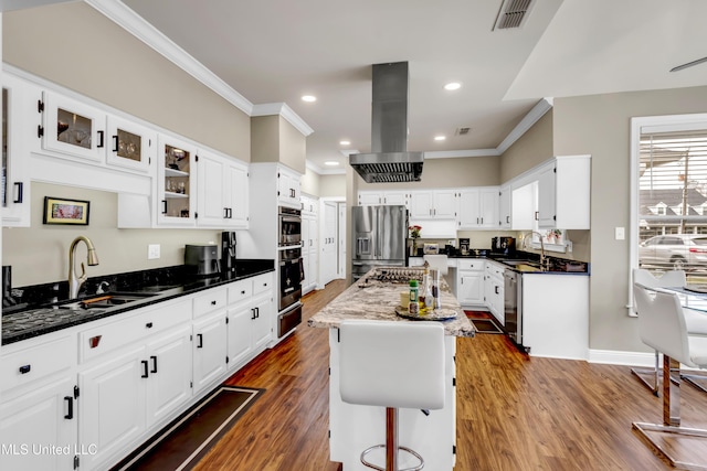 kitchen with visible vents, a sink, appliances with stainless steel finishes, a warming drawer, and island range hood
