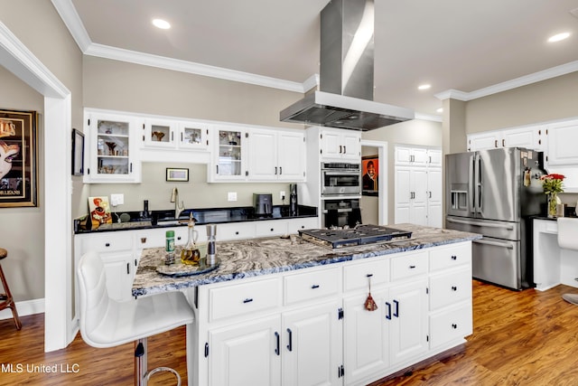 kitchen with a kitchen island, crown molding, light wood-type flooring, island range hood, and stainless steel appliances