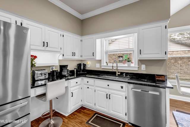 kitchen featuring plenty of natural light, wood finished floors, appliances with stainless steel finishes, and a sink