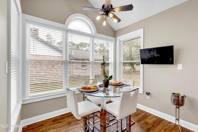 dining space with lofted ceiling, wood finished floors, and baseboards