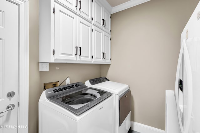 clothes washing area featuring baseboards, cabinet space, separate washer and dryer, and ornamental molding